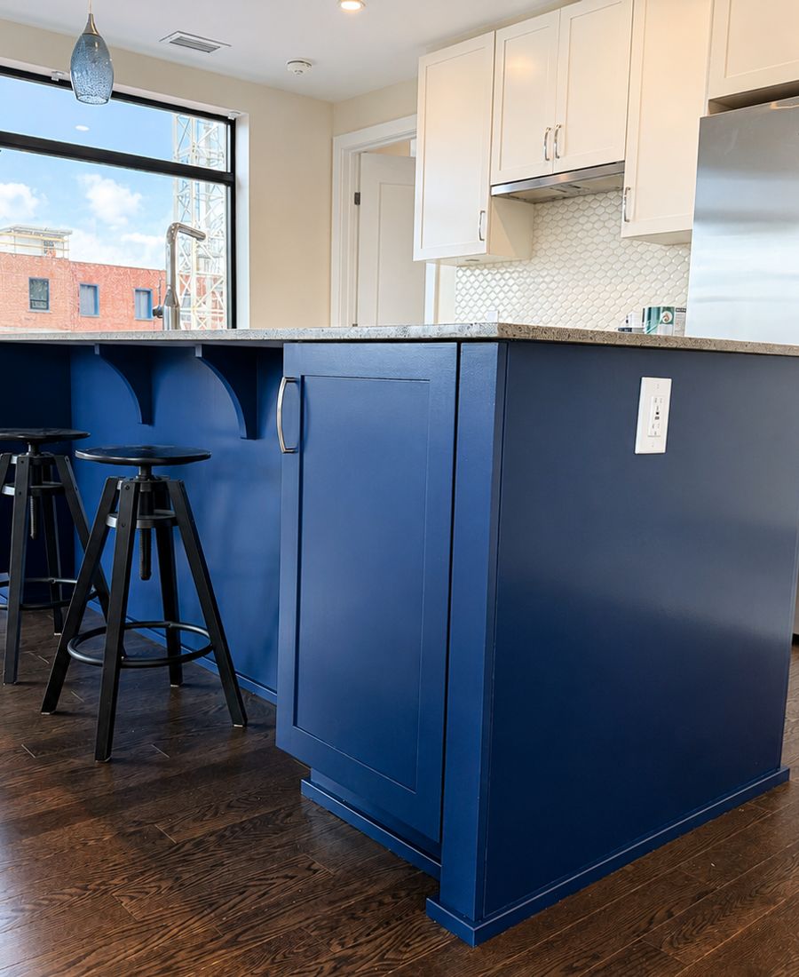 Navy blue painted kitchen island with white upper cabinets in a Glebe condo kitchen