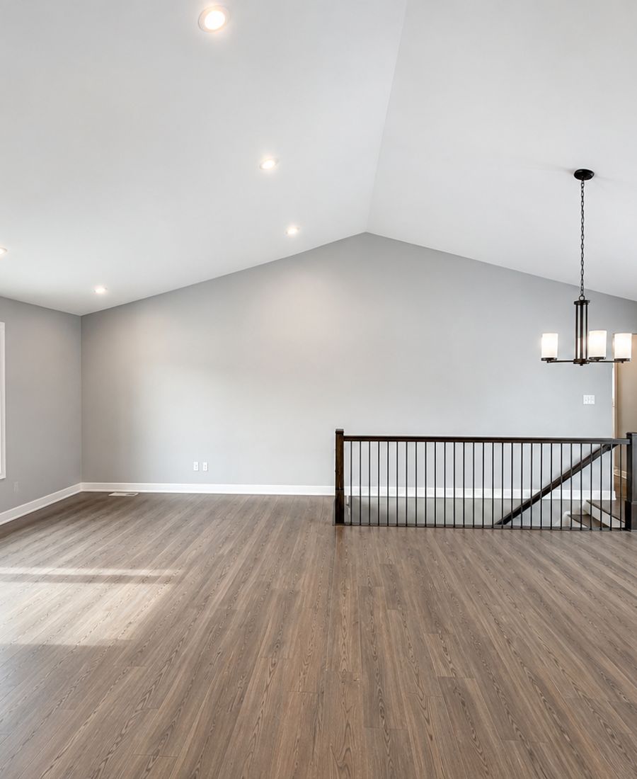 Bright open-concept living room with vaulted ceilings, light grey walls, and wide-plank hardwood floors in Kemptville
