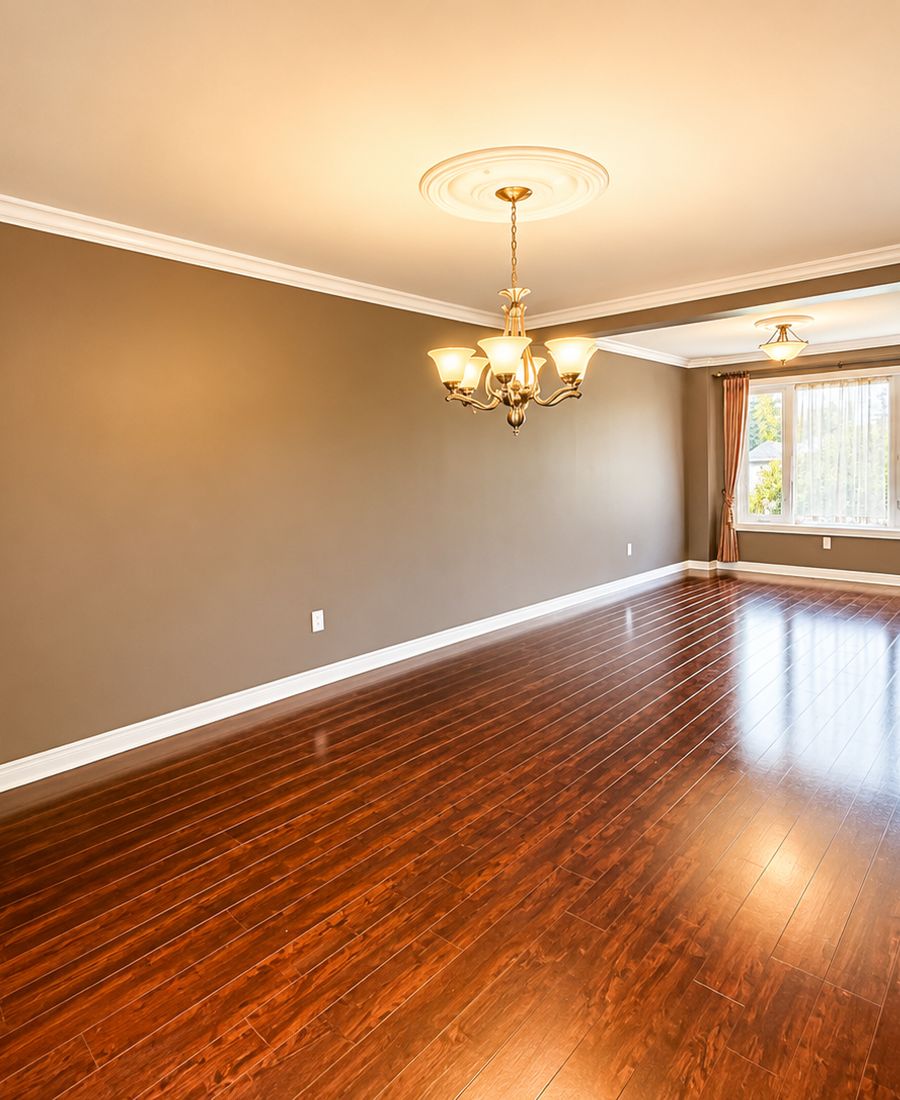 Freshly painted living and dining space with warm taupe walls, white crown molding, and refinished hardwood floors in Gloucester