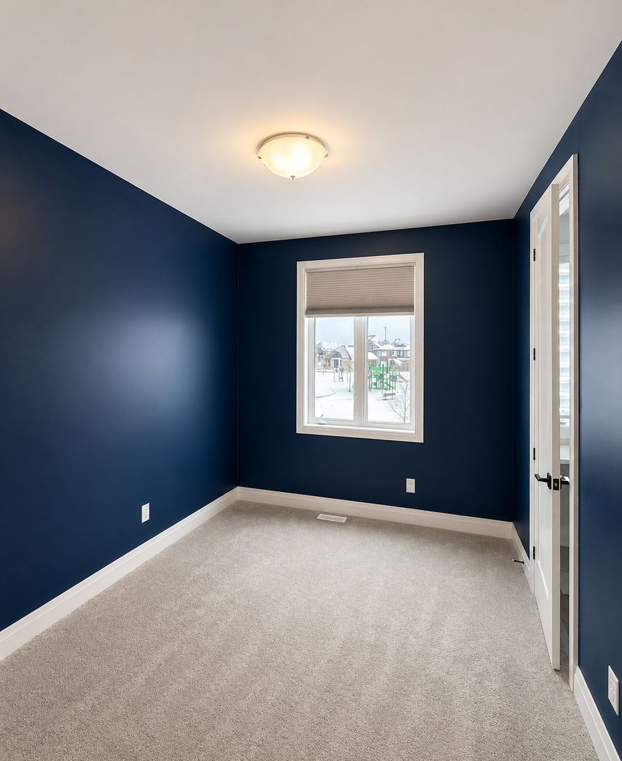 Master bedroom with deep navy walls, crisp white trim, white ceiling, and modern bedding in Barrhaven