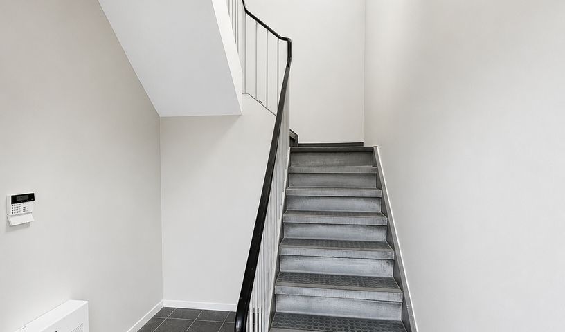 Freshly painted staircase with black railing and white walls in an Ottawa home